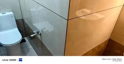 a bathroom with a toilet and a glass cabinet at Pranavam homestay in Guruvāyūr
