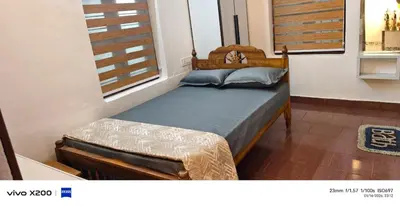 a small bedroom with a bed and a window at Pranavam homestay in Guruvāyūr
