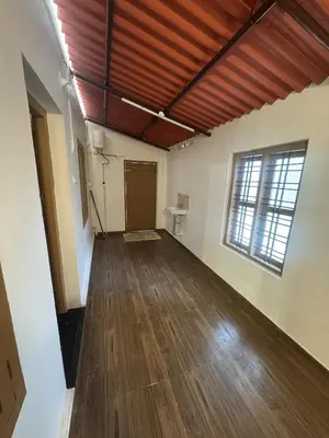 an empty room with a wooden floor and a window at Hibisco Hideout in Meenangadi