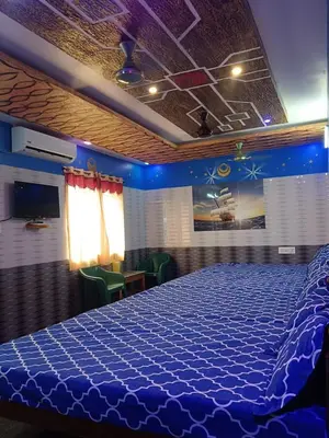 a bedroom with a large bed with a blue comforter at VR Residency in Wodapatti