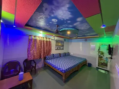 a bedroom with a bed and a colorful ceiling at VR Residency in Wodapatti