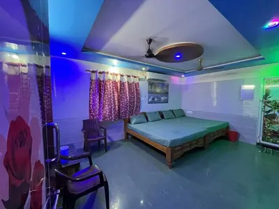 a bedroom with a bed in a room with purple lights at VR Residency in Wodapatti
