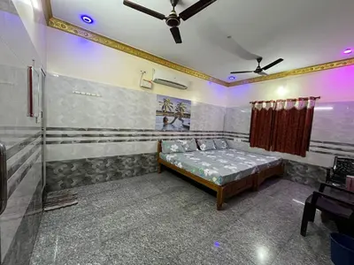 a bedroom with a bed and a ceiling fan at VR Residency in Wodapatti