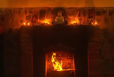 a fireplace with candles and a fire in it at Hullathy by Red Earth in Ooty