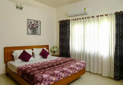 a bedroom with a bed and a window with curtains at River Whisper Homestay in Cochin
