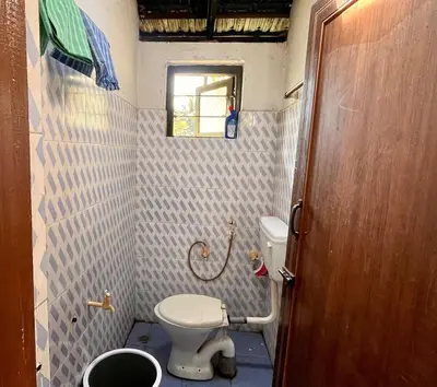 a small bathroom with a toilet and a window at Bean & Breeze in Suntikoppa