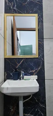 a bathroom with a sink and a mirror at Love Nest Inn Homestay in Agali