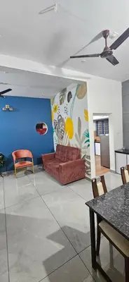 a living room with a red couch and a blue wall at Love Nest Inn Homestay in Agali