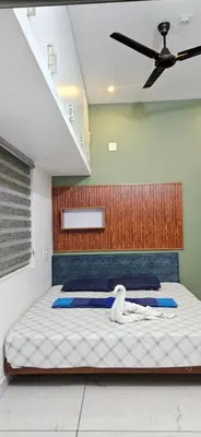a bedroom with a bed with a ceiling fan at Love Nest Inn Homestay in Agali