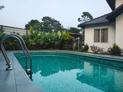 a swimming pool in front of a house at Tender leaf inn in Koroth