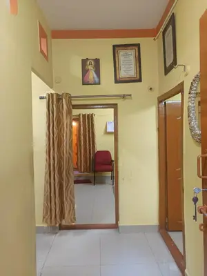 a room with a hallway with a door and a chair at Holy Family Nest 2 in Mysore