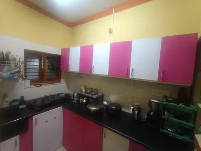 a kitchen with pink and white cabinets and a sink at Holy Family Nest 2 in Mysore