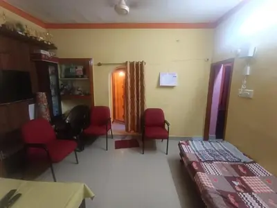 a waiting room with red chairs and a table at Holy Family Nest 2 in Mysore