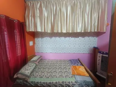 a small bed in a room with a window at Holy Family Nest 2 in Mysore