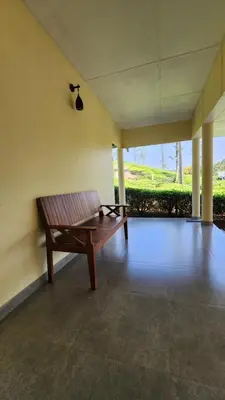 a wooden bench sitting in the middle of a room at The Bear's Lair 2BHK Chembra Peak View in Vythiri