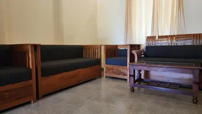 a room with three wooden benches and a table at The Bear's Lair 2BHK Chembra Peak View in Vythiri