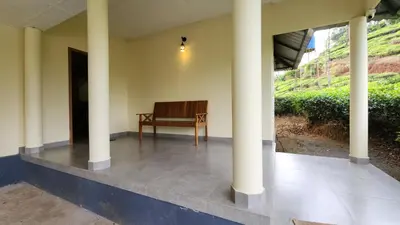 a bench sitting inside of a building with columns at The Bear's Lair 2BHK Chembra Peak View in Vythiri