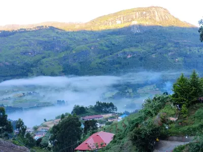 a view of a valley with fog in the mountains at Brooklyn Homestay in Vattavada