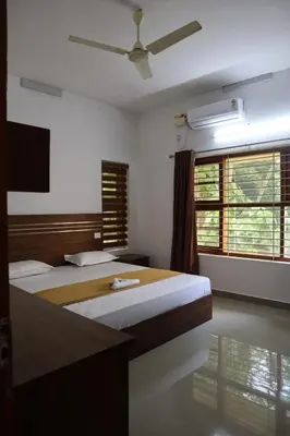 a bedroom with two beds and a ceiling fan at Athirappilly resort villa in Athirappilly