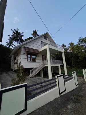 a small white house with a porch and stairs at Athirappilly resort villa in Athirappilly