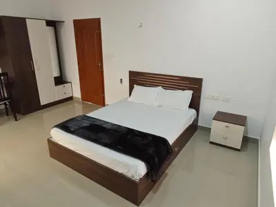 a bedroom with a large bed with white sheets at Athirappilly resort villa in Athirappilly