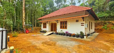 a small house in the middle of a forest at Mamoksha Riverdale in Padinjarathara