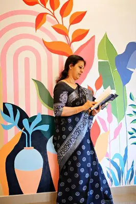 a woman standing in front of a wall with a book at Antara Luxury Homestay in Alwaye