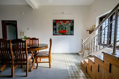 a dining room with a table and a painting on the wall at Antara Luxury Homestay in Alwaye