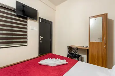 a room with a red bed with a flag on the wall at Grape Rooms in Perintalmanna