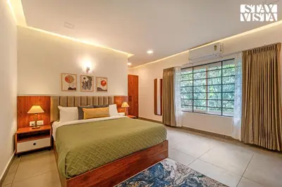 a bedroom with a large bed and a window at StayVista at Lagoons Kuruva with Shared Pool, Lawn in Chekadi