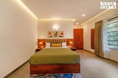 a bedroom with a bed and two lamps and a window at StayVista at Lagoons Kuruva with Shared Pool, Lawn in Chekadi