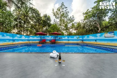 a swimming pool with a stuffed animal next to a pool at StayVista at Lagoons Kuruva with Shared Pool, Lawn in Chekadi