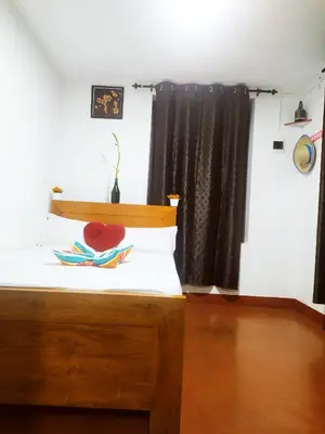a bedroom with a bed with a wooden head board at Coffee land in Kaniyāmbetta