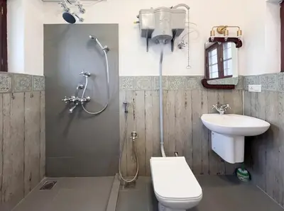 a bathroom with a shower and a toilet and a sink at Himalaya - 6bh Bunglow in Mysore