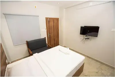 a room with two beds and a flat screen tv at Kanak Residency in Green Island