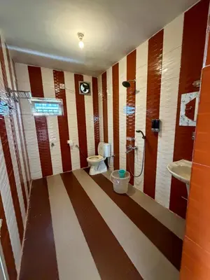 a bathroom with two toilets and a sink at DM&sons in Coonoor