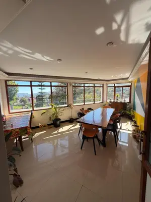 a dining room with a table and chairs and windows at DM&sons in Coonoor