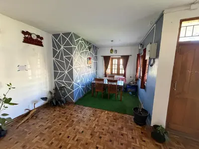a living room with a table and a dining room at DM&sons in Coonoor