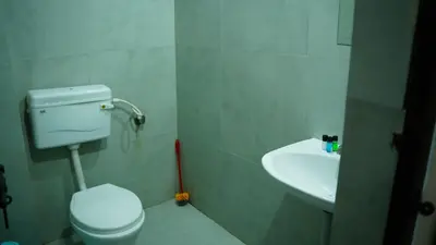 a bathroom with a toilet and a sink at Stay Ease Rental Rooms in Palakkad