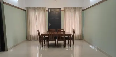 a dining room with a table and chairs and a door at The Rosetta Inn, Wayanad in Wayanad