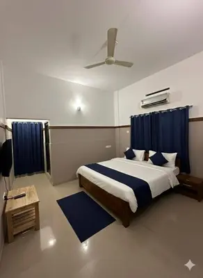 a bedroom with a bed and a ceiling fan at The Rosetta Inn, Wayanad in Wayanad