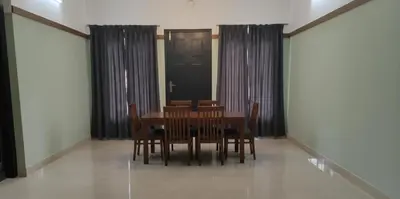a dining room with a table and chairs and a door at The Rosetta Inn, Wayanad in Wayanad