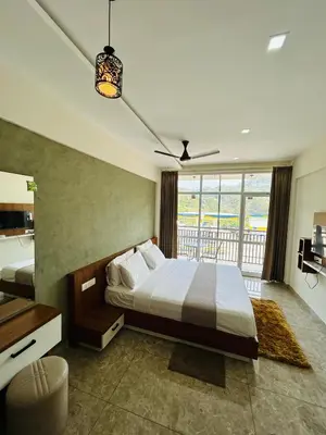 a bedroom with a large bed and a balcony at Dream wagon hotel lakkidi in Vythiri