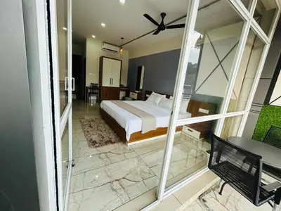 a bedroom with a bed and a balcony at Dream wagon hotel lakkidi in Vythiri