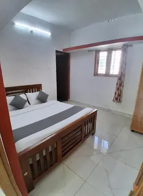 a bedroom with a large bed and a window at Kalpanahomestay in Vattavada