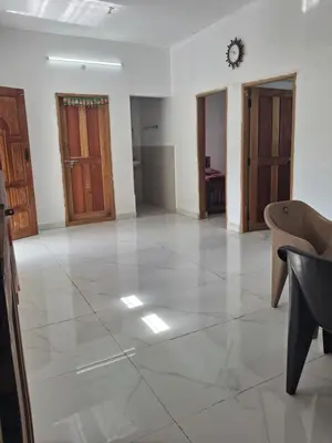a large empty room with wooden doors and tile floors at Kalpanahomestay in Vattavada