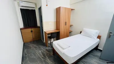 a small room with a bed and a desk at Jo Homes in Alwaye