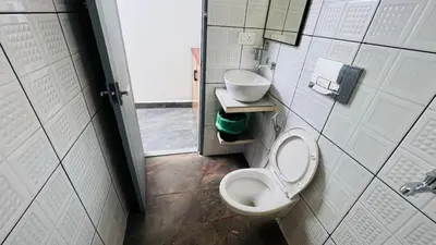 a bathroom with a toilet and a sink at Jo Homes in Alwaye