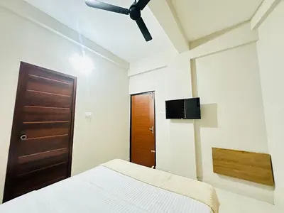 a bedroom with a bed and a ceiling fan at Nila Inn Calicut Near Hilite Mall in Kozhikode