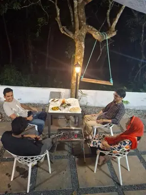 a group of men sitting in chairs around a table at Skygarden Resort Vythiri in Vythiri